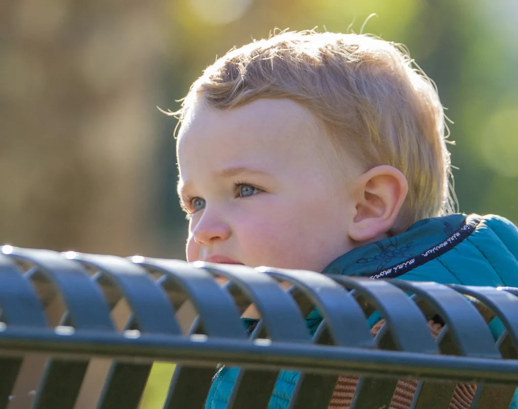 Portrait d’un bébé en extérieur, lumière naturelle et regard curieux, séance photo réalisée à Argeles Gazost