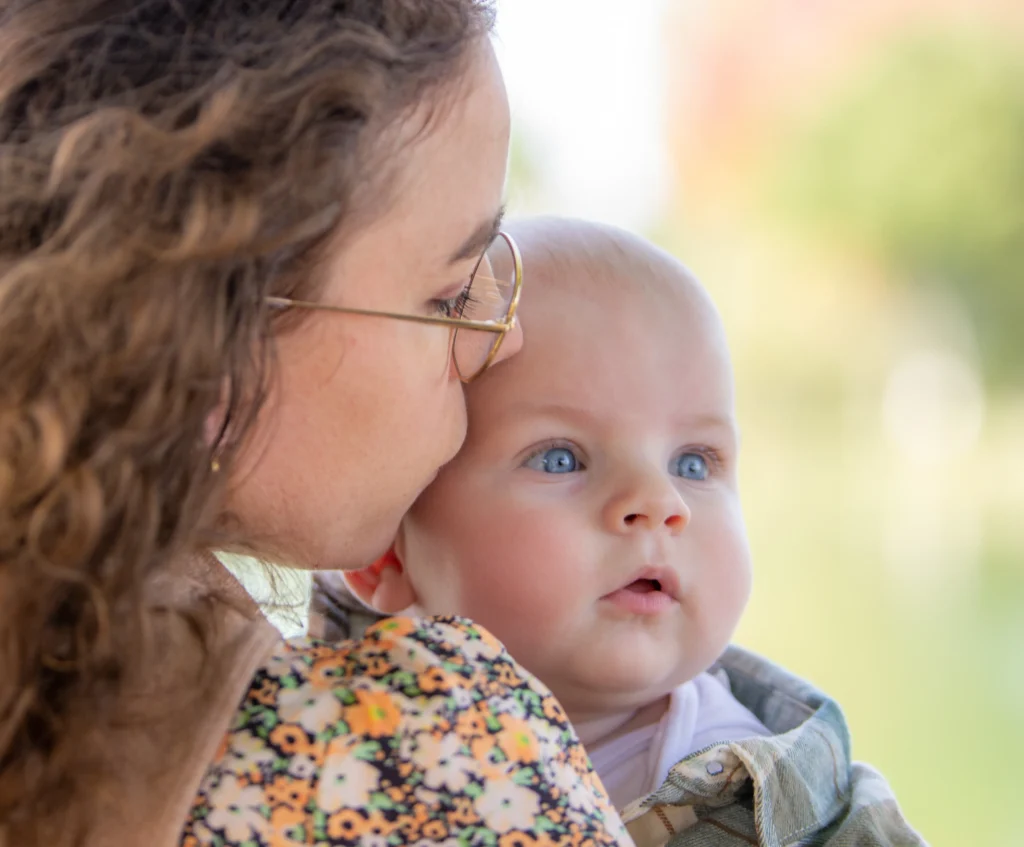 Photo de tendresse entre une maman et son bébé, regard complice et lumière naturelle, réalisée au lac à Soues