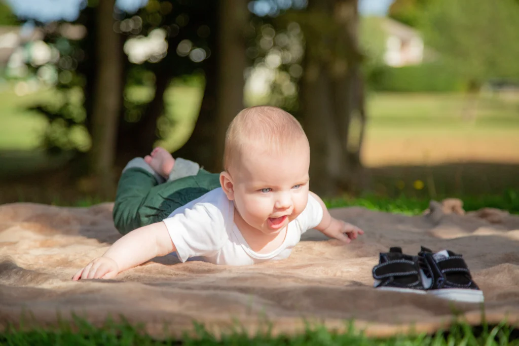 Photo d’un bébé allongé sur une couverture en extérieur à Soues, réalisée par LS Productions photographe naissance et famille