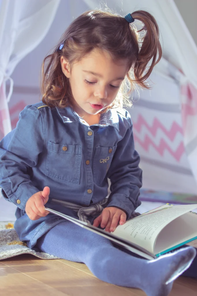 Photo d’une enfant lisant un livre près d’une tente de jeu à Bagnères-de-Bigorre, réalisée par LS Productions photographe famille et enfant