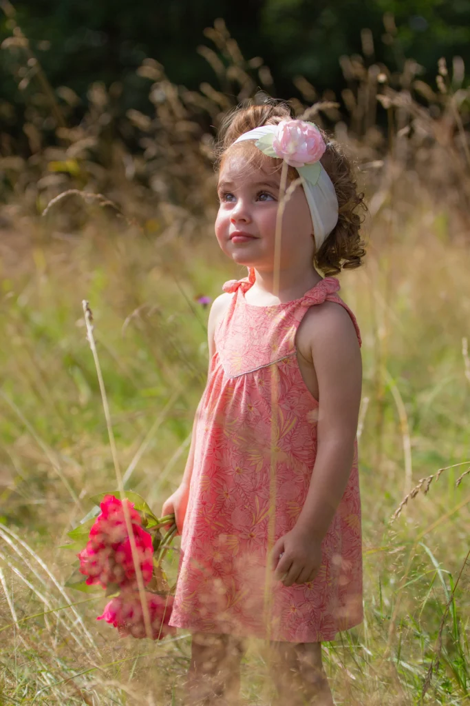 Portrait d’une petite fille tenant un bouquet de fleurs dans un champ à Pouzac, réalisée par LS Productions photographe famille et enfant