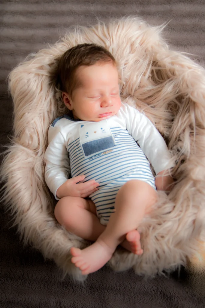 Photo de naissance d’un bébé endormi dans un panier douillet à Tarbes, réalisée par LS Productions photographe naissance